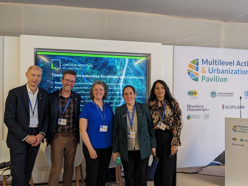 The Lincoln Institute’s John Farner and Amy Cotter pose with partners at the COP28 Multilevel Action & Urbanization Pavilion.